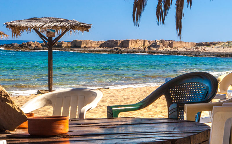 Romantic beach bar opposite the remains of the Venetian limestone quarry in Stavros beach